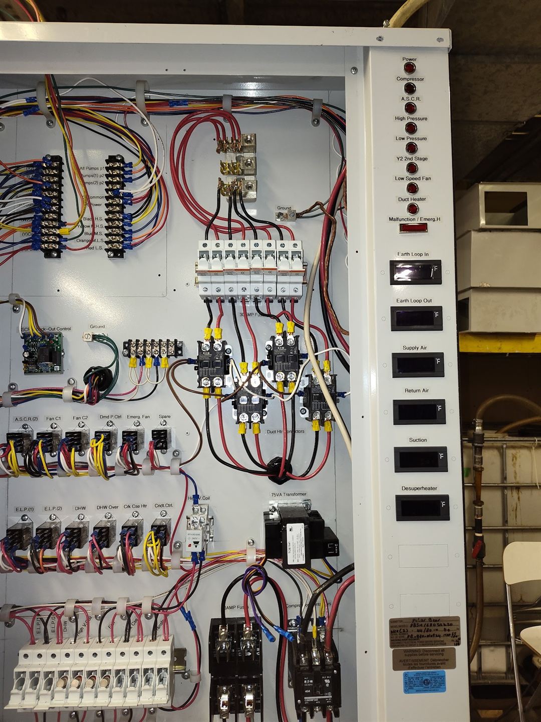 Open control cabinet with relays and terminal blocks.