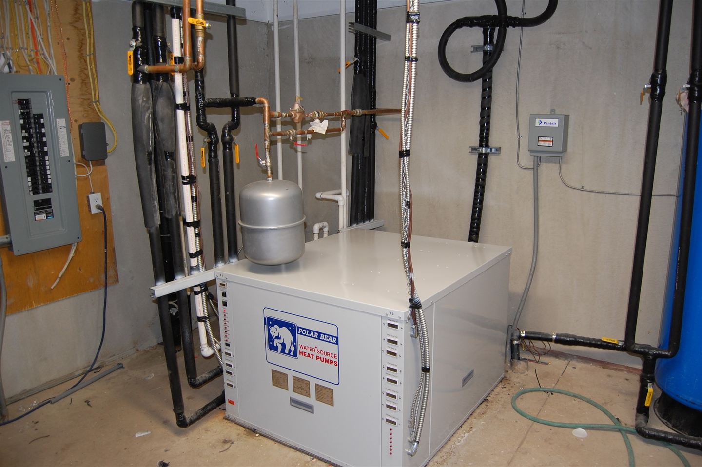 Heat pump installed in a basement mechanical room.